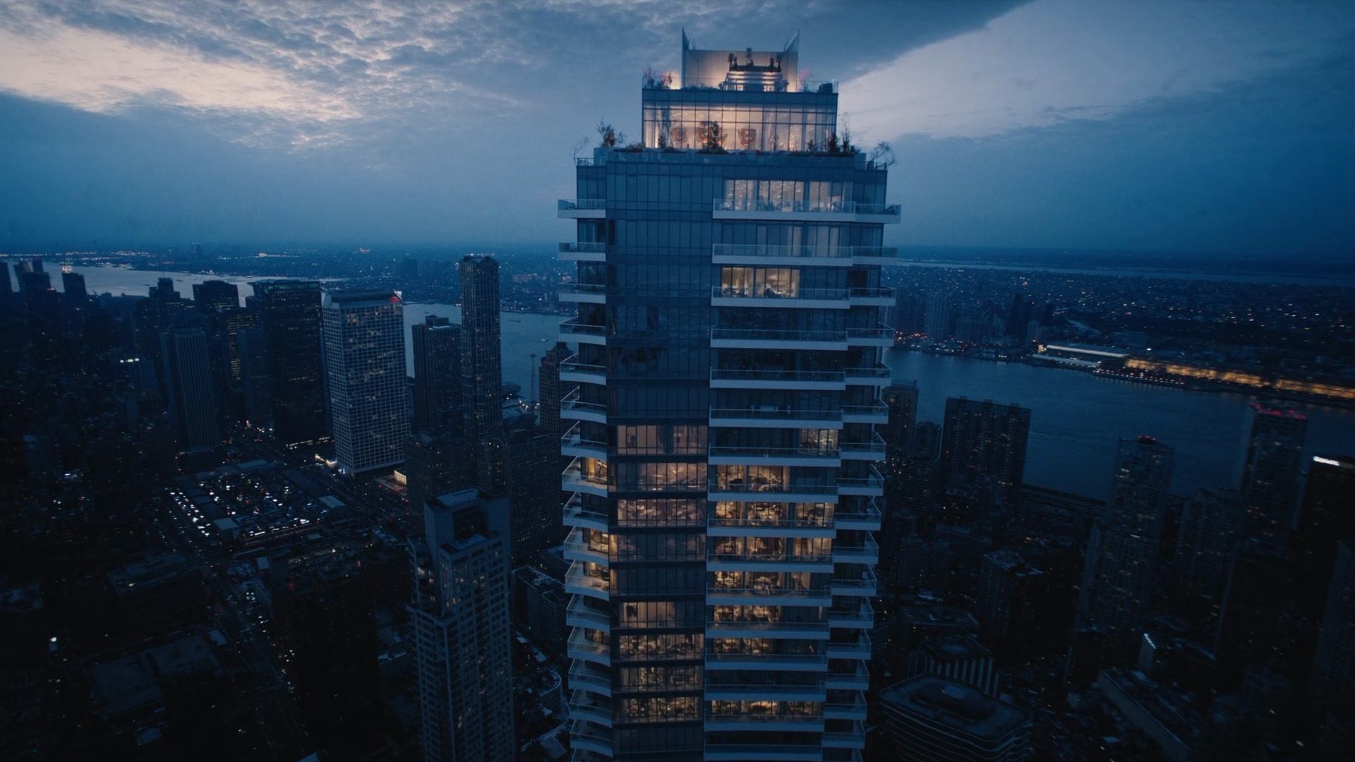 The sky lounge and planted roof terrace at the top of Kestrel House, lit at dusk above the city.